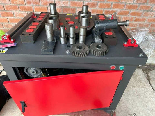 Máquina dobladora de fierros corrugado CNC con diferentes herramientas y engranajes visibles para procesos de doblado.