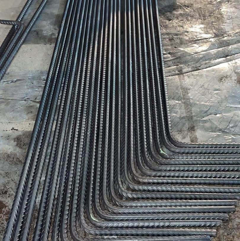 Variedad de varillas de fierro corrugado preparadas para doblado con CNC.